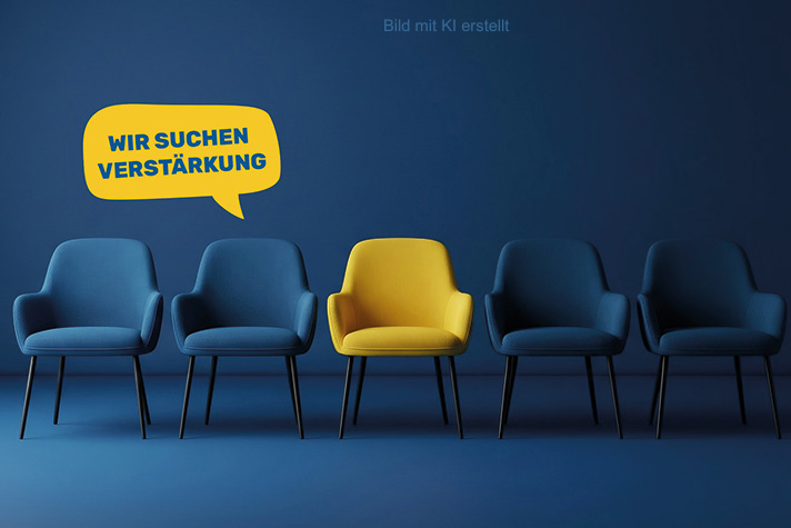 Fünf gepolsterte Stühle stehen horizontal in einer Linie nebeneinander. Der Stuhl in der Mitte ist gelb und an ihm hängt eine gelbe Sprechblase mit dem Text "Wir suchen Verstärkung". Die anderen Stühle sind dunkelblau, genau wie die Wand dahinter und der Fußboden.